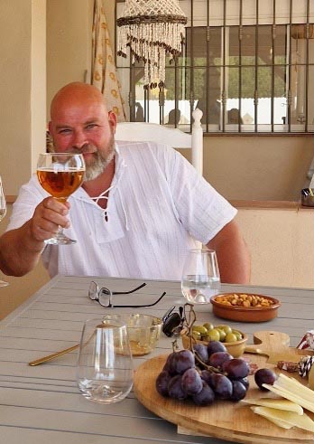 Edgar geniet van een biertje op het terras bij zijn huis in Real, Valencia.